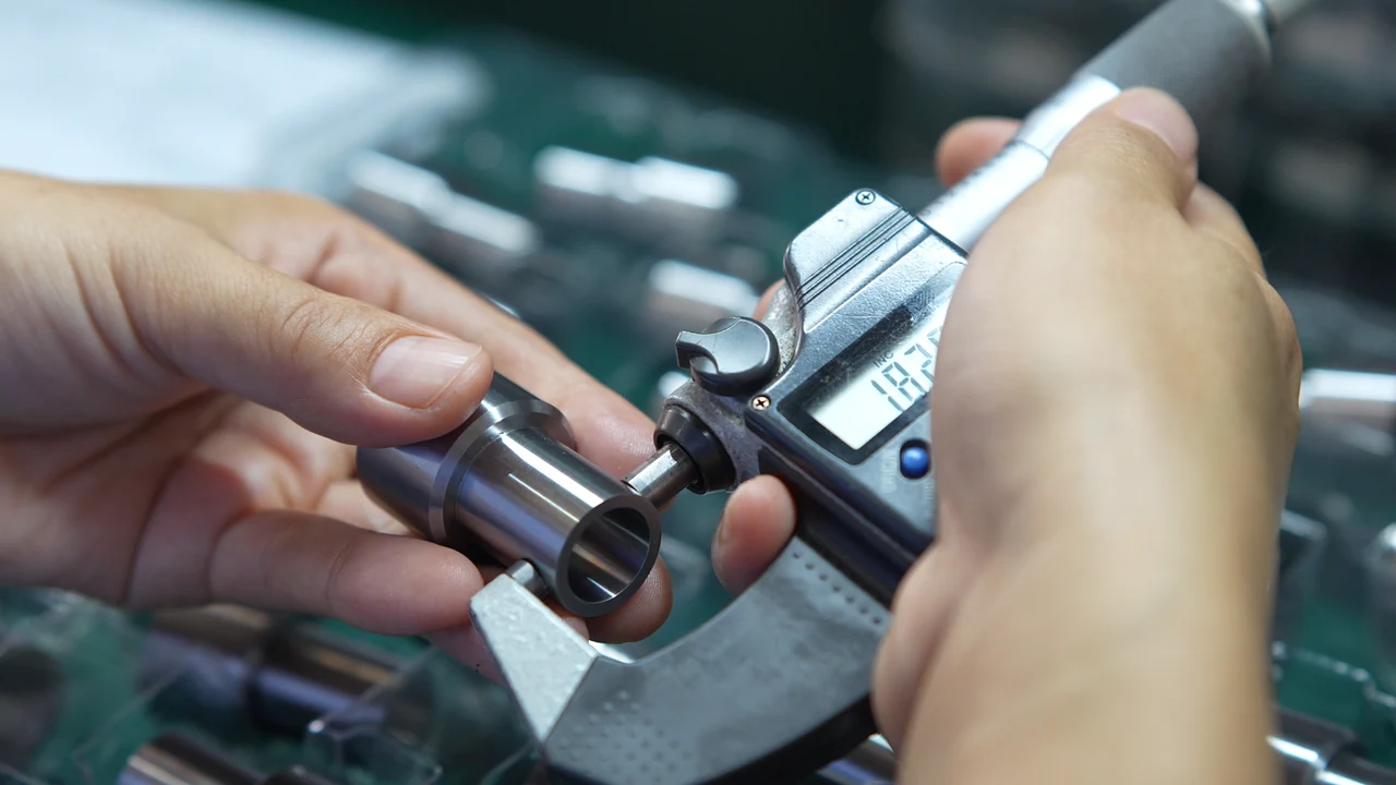 Micrometer measurement of a cylindrical metal component.