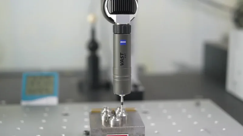CMM probe measuring a machined component held on a fixture