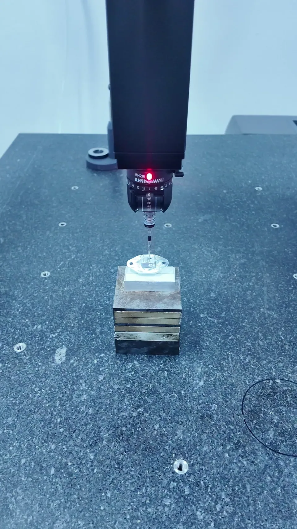 A measurement probe and a small component secured on a fixture.