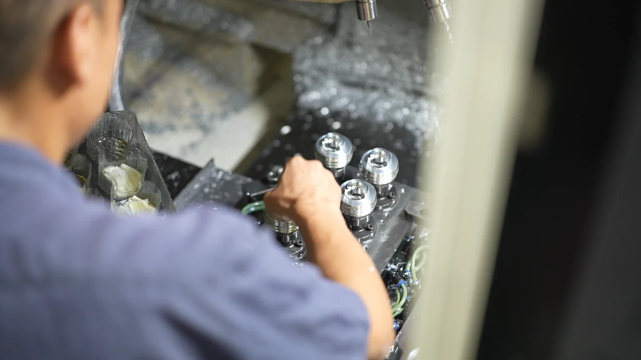 Operator attending a component machining fixture